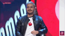 a man wearing a black leather jacket and a white shirt with a heart shaped pendant that says rafa on it