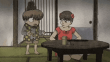 a girl in a red dress sits at a table with a boy standing next to her