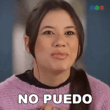 a woman in a purple sweater is making a funny face and says no puedo