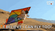 a man is flying a kite with the words " i believe i can fly too " above him