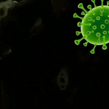 a green laser is pointing at a green virus on a black background