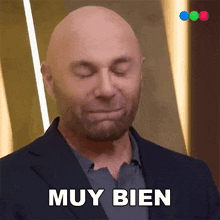 a bald man in a suit is making a face and saying muy bien