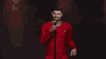 a man in a red shirt with the number 7 on it is holding a microphone