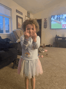 a little girl giving the middle finger in front of a tv that says 97