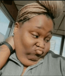 a woman with braids on her head making a face