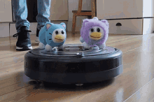 a vacuum cleaner with two stuffed animals on it