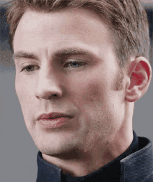 a close up of a man 's face with a blue shirt on .