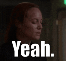 a woman with red hair says yeah in front of a green exit sign