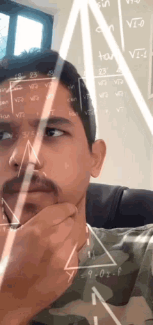 a man with a beard is looking at a math problem on a board
