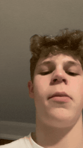 a young man with curly hair is making a funny face