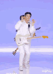 a man holding a guitar in front of a blue background that says ' imgplay ' on it