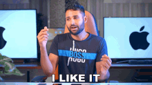 a man wearing a hugo boss t-shirt is sitting at a desk