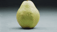 a pear with water drops on it is sitting on a table
