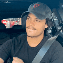 a man wearing a hat and a black shirt is in a car