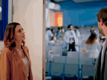 a man and a woman are looking at each other in a room
