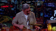 a man is sitting at a desk with a microphone and a bottle of tequila