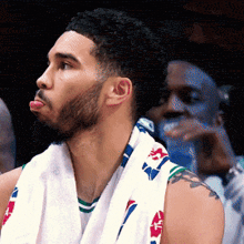 a man with a towel around his neck has a tattoo on his arm