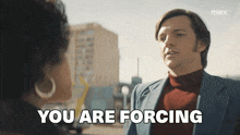 a man in a suit is talking to a woman with the words " you are forcing " above him
