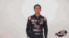a man wearing a liberty university jacket waves his hand