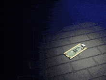 a small motherboard is laying on a black tile floor