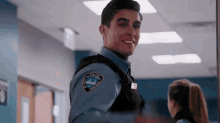 a police officer is standing in a hallway with a woman .