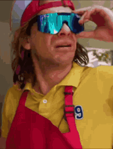a man wearing sunglasses and a yellow shirt with the number 9 on the front