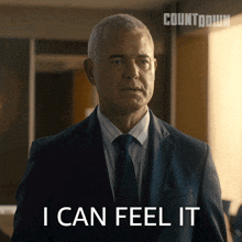 a man in a suit and tie has the words i can feel it on his face