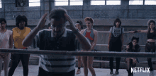a group of women are standing around a man in a boxing ring with netflix written on the bottom
