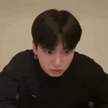 a close up of a person 's face with a black shirt and hoop earrings