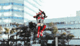a man in a red and black costume is flying in the air