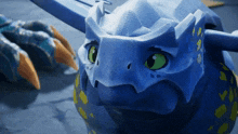 a blue dragon with green eyes and yellow spots