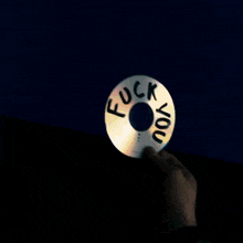 a person is holding up a cd that says " fuck you "