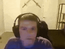 a man wearing headphones is sitting in front of a computer screen in a room .