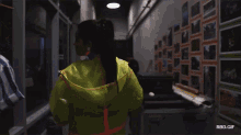 a woman in a neon green jacket is walking down a hallway next to a man