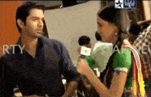 a man is being interviewed by a woman who is holding a microphone in front of a star advertisement