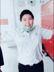 a young boy wearing a green mask is standing in a classroom .