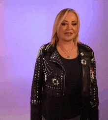 a woman is wearing a black leather jacket and a black shirt