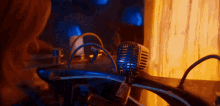 a person is looking at a microphone in a dark room with a blue light coming out of it .
