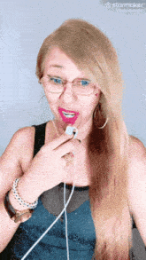 a woman with long blonde hair and glasses is using a starmaker app on her phone
