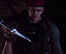 a man wearing a red beret is holding a knife in his hand