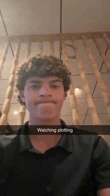 a young man with curly hair has a snapchat caption that says watching plotting