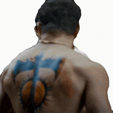 a man has a tattoo on his back that looks like a sun
