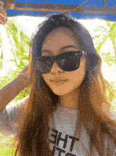 a girl wearing sunglasses and a shirt that says eht