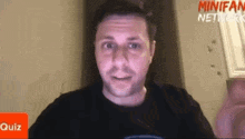 a man is sitting in front of a minifan network quiz
