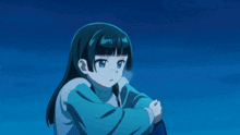 a girl in a blue sweater looks at something in the distance