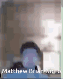 a blurred image of matthew brian nigro with a white box in the background
