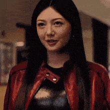 a woman is wearing a red leather jacket and a black top