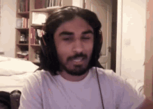 a man with long hair and a beard wearing headphones and a white shirt