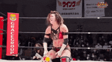 a woman in a wrestling ring with a sign that says gracegroup on it