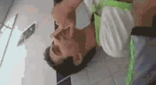 a man is laying on a bed holding his nose .